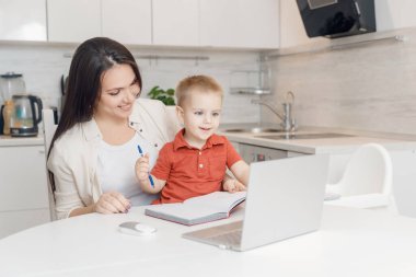 Anne ve oğul yazmayı öğreniyorlar. Kadın çocuk alfabesi öğretiyor Online çalışma