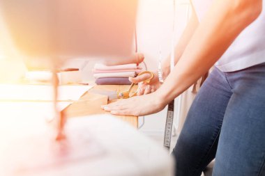 Genç bayan tasarımcı elbise ve giysi dikmek için makasla çizim çizgisinden kumaş kalıplarını kesiyor.