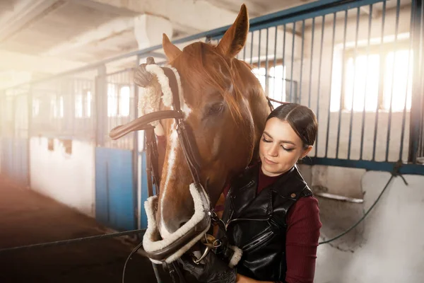 Cavalier jeune femme met sur bride et selle sur cheval — Photo