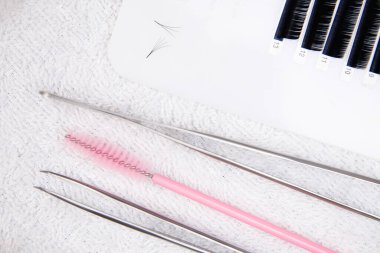 Kirpik uzatma için yakın çekim aracı. Cımbız ustası çalışıyor.