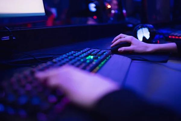 Profesional jugador en línea dedos de la mano teclado mecánico en neón color borroso fondo. Enfoque suave, vista trasera — Foto de Stock