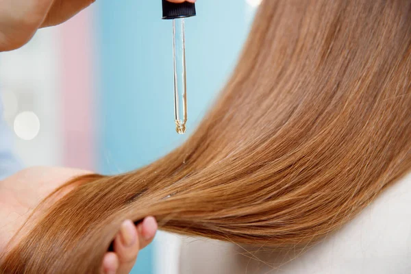 Gros plan goutte d'huile restaurer et récupérer les cheveux est appliqué sur les ampoules de tête. salon de coiffure spa. — Photo