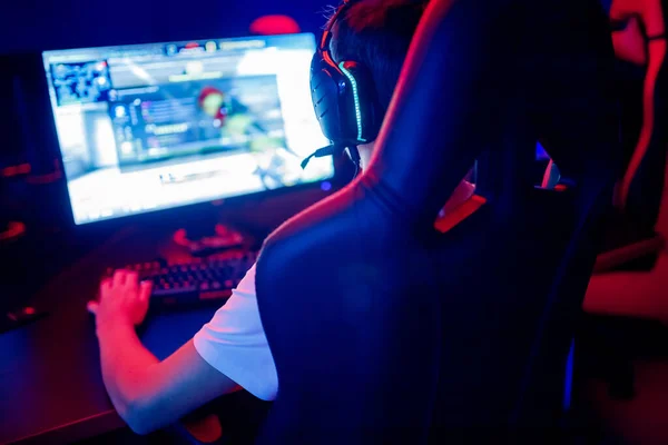 Professional gamer playing online games tournaments pc computer with headphones, Blurred red and blue background — Stock Photo, Image