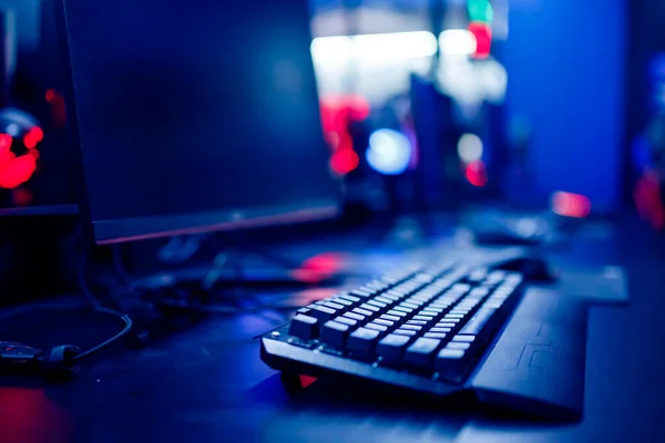 Sala de estudio profesional de videojuegos cibernéticos con sillón de computadora personal, teclado para flujo en fondo borroso de color neón. Enfoque suave —  Fotos de Stock