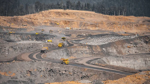 Industria minera a cielo abierto. Camión minero amarillo para carbón se mueve a lo largo de carretera de cantera polvorienta — Foto de Stock