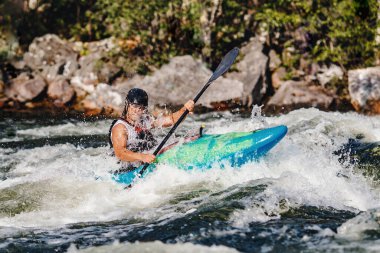 Ekstrem spor rafting beyaz su kayağı. Kanodaki adam dağ nehrine yelken açıyor.