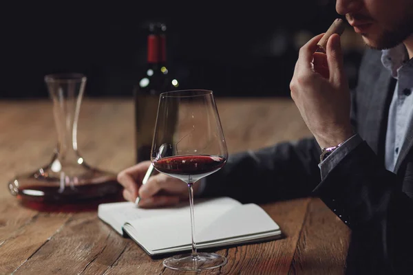 Sommelier sestavuje ochutnávku alkoholu pro restauraci, vyhodnocuje červené víno ve skle — Stock fotografie