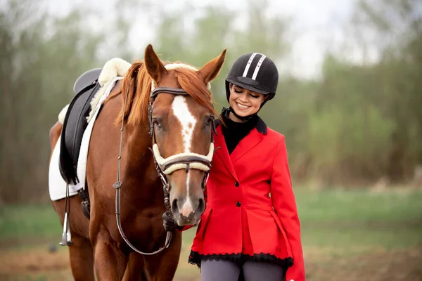 Sport équestre Femme sourire jockey tenant cheval par bride à l'extérieur — Photo