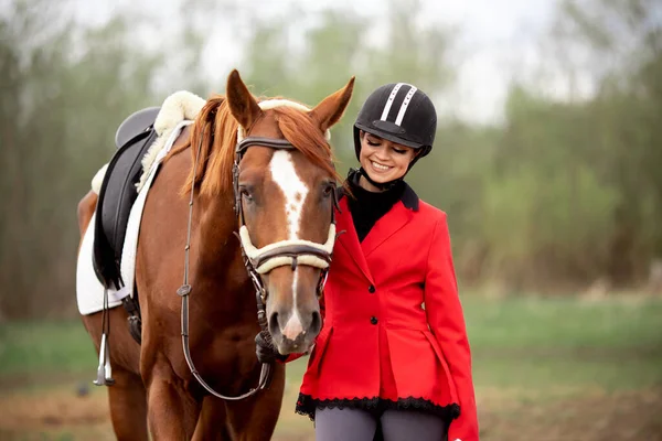 Equestrian sport Woman smile jockey holding horse by bridle outdoors — Stock Photo, Image