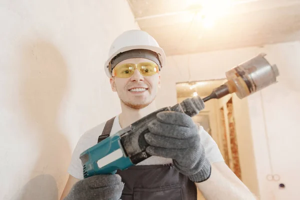Constructor hombre trabajador hace foto selfie con gafas de seguridad y casco blanco con taladros de martillo neumático — Foto de Stock