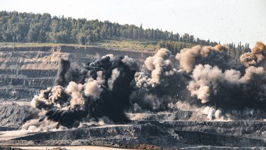 Açık kömür madeni endüstrisinde patlayıcı çalışmalar. Toz ve duman bulutları gökyüzünde, lanet toprak