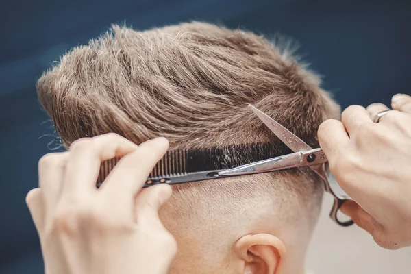Master barbeiro detém tesoura e pente para cortar cabelo ao cliente no salão de homens — Fotografia de Stock