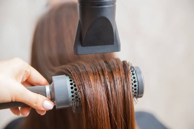 Güzellik salonunda yakın çekim saç bakımı, spa efekti, usta saç kurutma makinesini kurutur.
