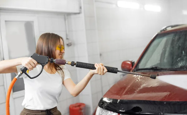 İşçi kadın temiz köpük için yüksek basınçlı su kullanarak araba temizleme — Stok fotoğraf