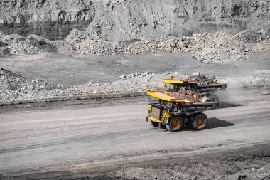 Açık maden endüstrisi. Kömür için sarı maden kamyonu tozlu taş ocağı yolunda ilerliyor
