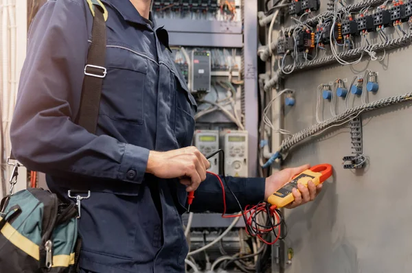 Villamosmérnök ellenőrzi az elektromos áramkört a vezérlőpanelben magas áramerősség és feszültség, indító és üzembe helyező relék ipari termelés — Stock Fotó