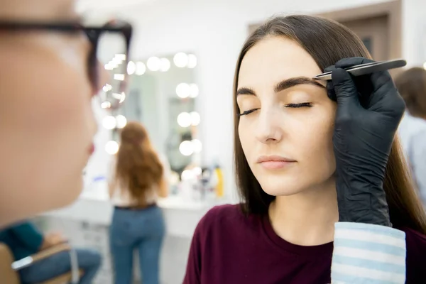 Corrección de cejas maestro pinzas depilación del pelo de la ceja en las mujeres —  Fotos de Stock