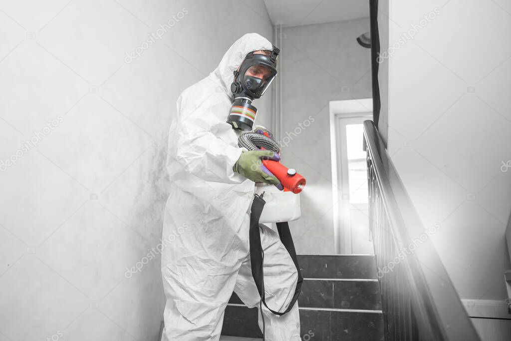 Concept coronavirus disinfection. People in hazmats making cleaning in stairwell of apartment building