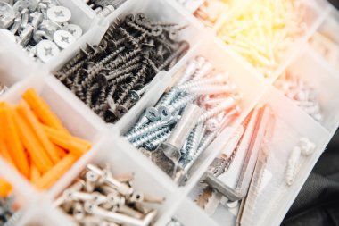 Küçük inşaat eşyalarıyla dolu bir çanta. Vidalardan, çapalardan, çivilerden oluşan metal alet kutusunu ayarla