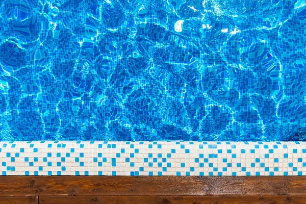 Top view blue swimming pool with teak wood flooring stripes sunlight — Stock Photo, Image