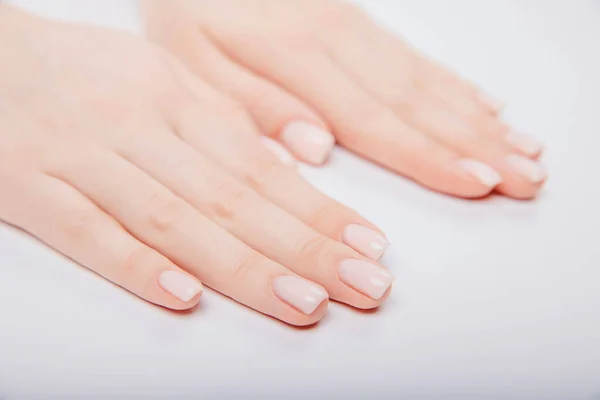 Unha na moda elegante jovem mulher mãos rosa manicure no fundo branco — Fotografia de Stock