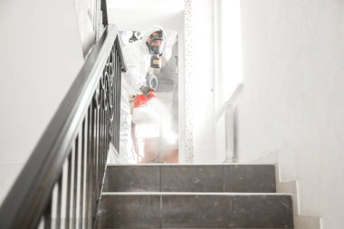 Beyaz koruyucu giysiler, dezenfekte hücreleri, koronavirüs salgınını, açık virüs ev salgınını temizleme uzmanı.