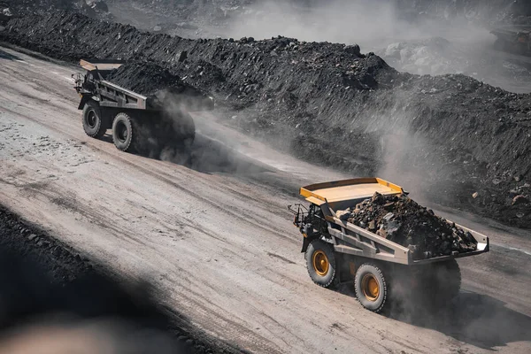 광산 산업을 개방하 세요. 먼지가 많은 채 석장 길을 따라 석탄을 싣기 위한 황색 광차가 운행 된다 — 스톡 사진