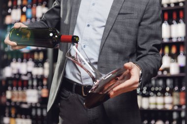 Sommelier hava içeceği yapmak için sürahi sürahide kırmızı şarap dolduruyor.
