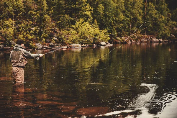 Bobina de cuerda de pesca con mosca, las manos del hombre sosteniendo la barra —  Fotos de Stock