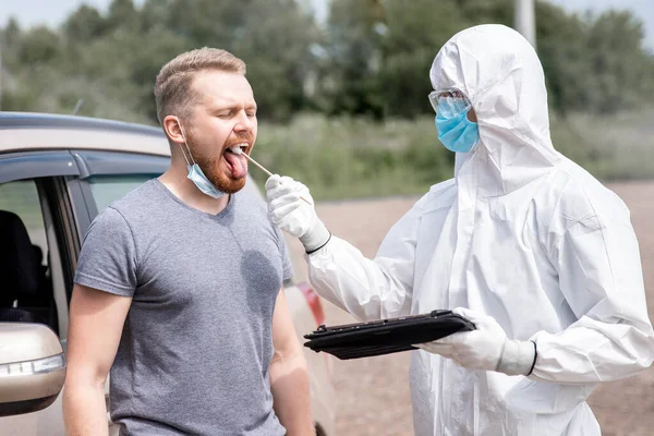 Prueba de frotis para coronavirus COVID-19 para el conductor, restringiendo el movimiento en el coche. Concepto prohibición de viajar a través de la frontera — Foto de Stock