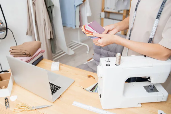 Designer feminina costureira trabalhando na máquina de costura em estúdio. Formas paleta de cores para costurar roupas de moda — Fotografia de Stock