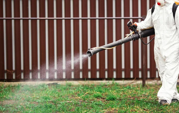 Desinfección de parques recreativos del virus coronavirus, trabajador en traje protector con spray — Foto de Stock