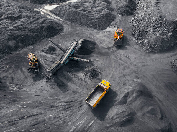 Open pit mine industry, big yellow mining truck for coal, top view aerial drone
