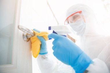 Evin dezenfeksiyon ve temizlik kapı kolları. Biyokimyasal kıyafetli mikroplar ve virüs enfeksiyonundan. Coronavirus koruma kavramı