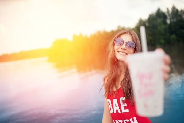 Jeune femme en maillot de bain rouge tient verre avec cocktail sur la plage — Photo
