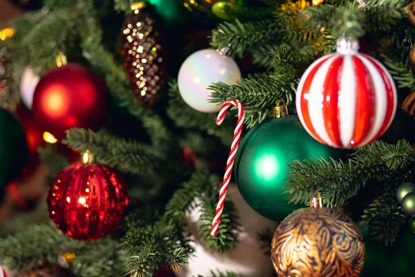 Weihnachten Hintergrund Baum Zweig mit Dekorationen Zuckerlutscher rote und grüne Kugeln, mit Bokeh-Licht — Stockfoto