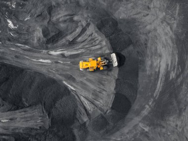 Sarı kazıcı kömür yüklüyor. Pit mayını, çıkarıcı endüstri, üst hava manzarası.
