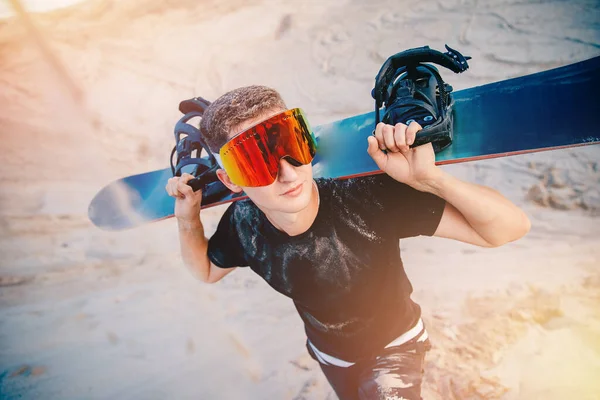 Snowboarder sale in cima alla duna di sabbia per lo snowboard — Foto Stock