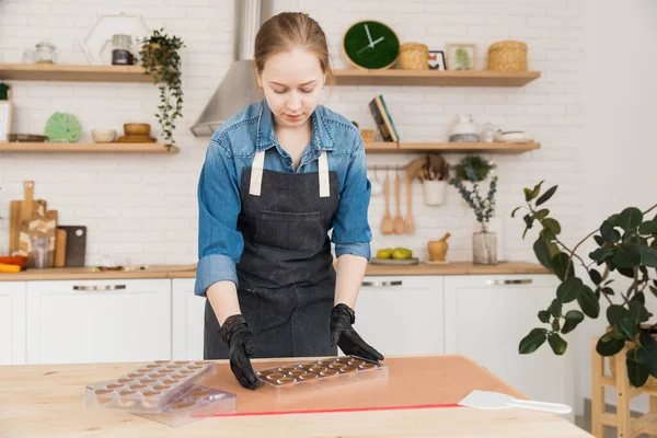 Chef o cioccolatiere versando cioccolato fondente fuso in stampi in silicone sulla borsa da pasticceria. Concetto casa pasticceria, piccola impresa — Foto Stock