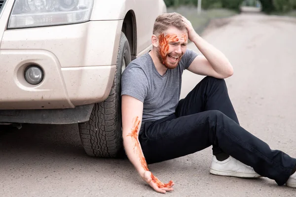 A fiatalember véres fejjel ül a volán mellett, sikoltozik és megbánja tettét. — Stock Fotó