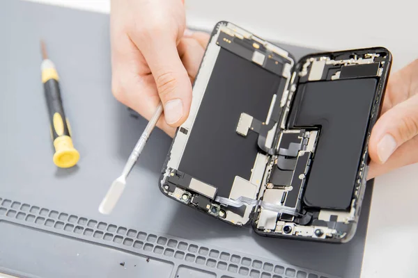 Процесс ремонта мобильных телефонов, замена аккумуляторов и сломанный экран для переработки — стоковое фото