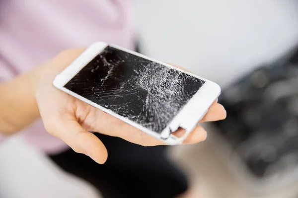 Pantalla de cristal roto del teléfono en manos de la mujer, fondo blanco — Foto de Stock