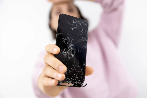 Broken glass screen of phone in hands of woman, white background