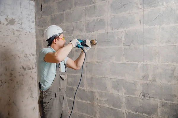 Trabajador constructor taladros de martillo neumático agujero en la pared de ladrillo de hormigón con corona de diamante para cable eléctrico, zócalo, interruptor — Foto de Stock