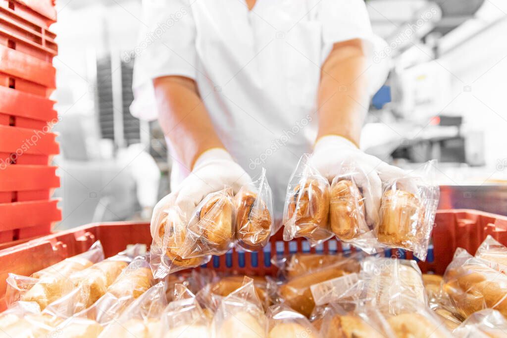 Working baker packs baked goods into individual bag for sale