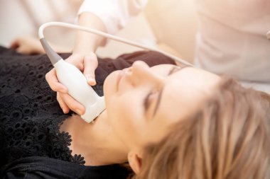 Klinikteki doktordan ultrason testi yaptıran kadın.