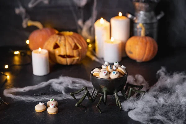 Dulces y galletas de halloween estilizadas para vacaciones sobre fondo oscuro con telarañas, calabazas y velas — Foto de Stock