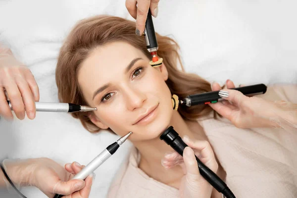 El médico realiza un procedimiento de spa cosmético RF lifting masaje facial eléctrico para la piel de la cara de la mujer joven —  Fotos de Stock