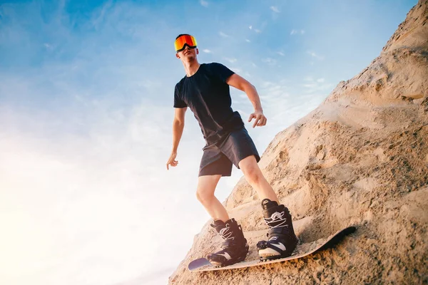 Arena de descenso extremo en snowboard en el desierto. Hombre snowboarder en las dunas — Foto de Stock