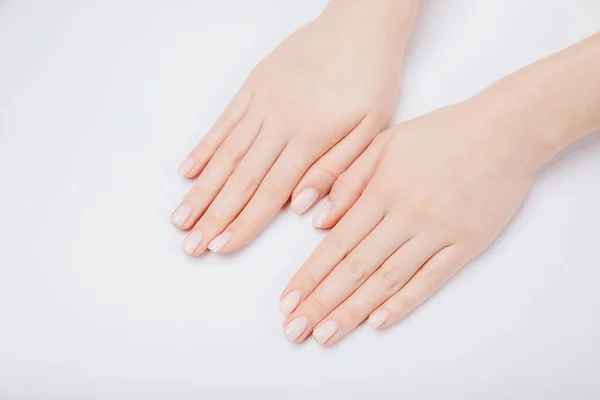 Elegante moderno prego jovem mulher mãos rosa manicure no fundo branco, vista superior — Fotografia de Stock